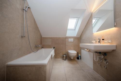 a bathroom with a sink and a tub and a toilet at Zurich Furnished Homes in Zürich