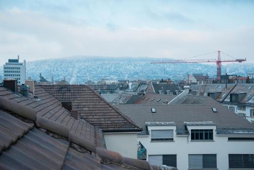 a view of a city with roofs and a crane at Zurich Furnished Homes in Zürich