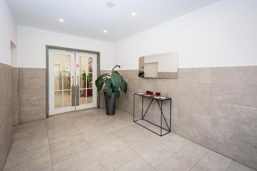 a living room with a potted plant and a kitchen at Zurich Furnished Homes in Zürich