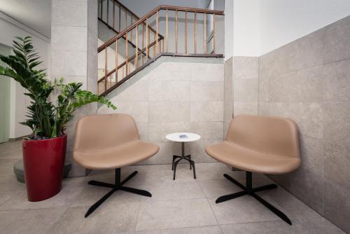 two chairs and a table in a room with stairs at Zurich Furnished Homes in Zürich