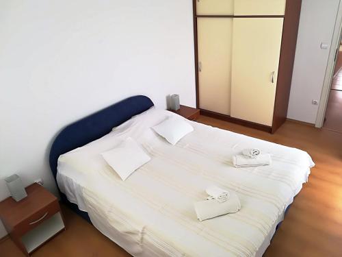 a bedroom with a bed with white sheets and a mirror at Apartman Rosanda in Premuda