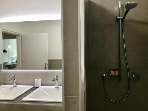 a bathroom with two sinks and a shower at City Apartment 221 in Merano