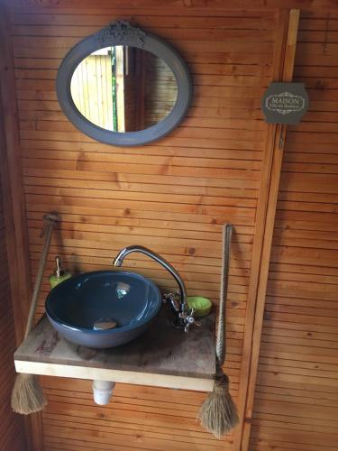 ein Waschbecken in einem Zimmer mit Spiegel und Spiegel in der Unterkunft Le Chalet dAZAE in La Rivière