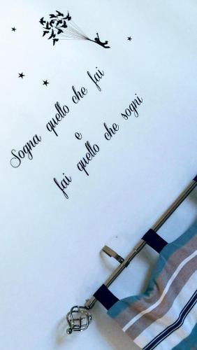 a letter with a pair of scissors on a wall at Blue Apartment in Pescara