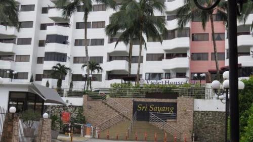 a sign in front of a building with palm trees at The Barn private home @ Sri Sayang Apartment in Batu Ferringhi