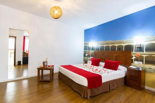 a bedroom with a large bed with red pillows at Hotel El Tajo & SPA in Ronda