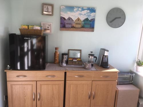 a kitchen with a refrigerator and a clock on the wall at Luxury 3 bedded room with sea peeps and parking in Paignton