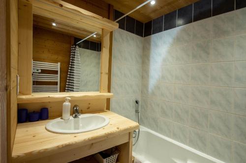 a bathroom with a sink and a bath tub at Les Adrets in Gérardmer