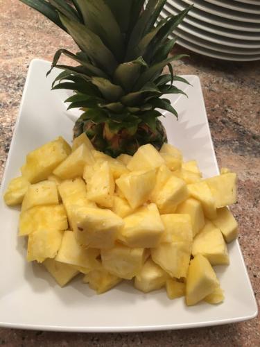 a plate with a pineapple and a pile of pineapple slices at Das kleine, feine SONNWEND in Alpbach