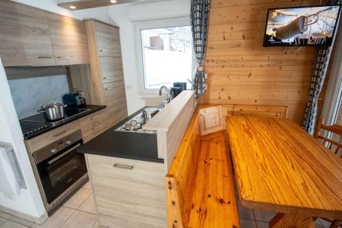 a kitchen with a wooden counter top and a sink at Les Adrets in Gérardmer