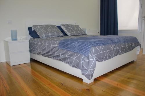 a bedroom with a bed and a wooden floor at Banho de Mar in Póvoa de Varzim