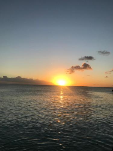 a sunset over the ocean with the sun setting at Heywoods Villa in Saint Peter