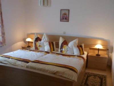 a bedroom with a large bed with two lamps at Ferienwohnung Sonja in Prackenbach