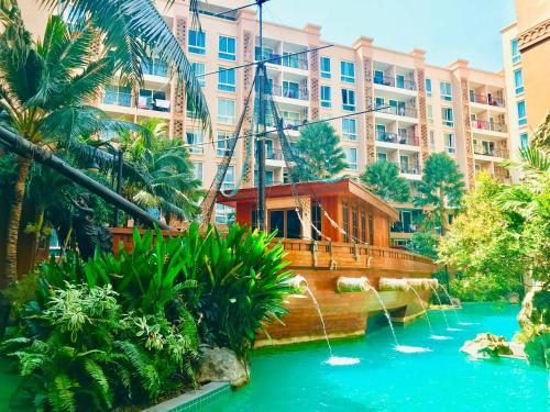 a boat in the water in front of a building at Atlantis Condo & Resort by Luxury Collection Apartment in Jomtien Beach