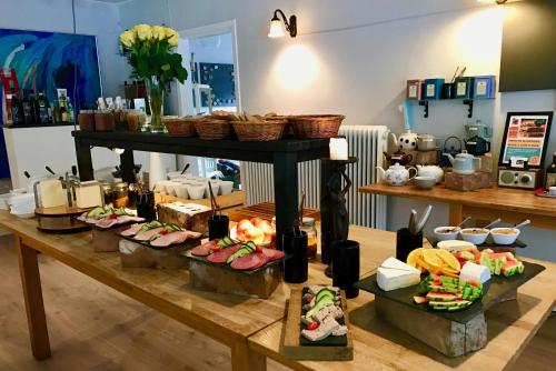 una mesa con muchos tipos diferentes de comida en ella en Hotel Skovly en Rønne