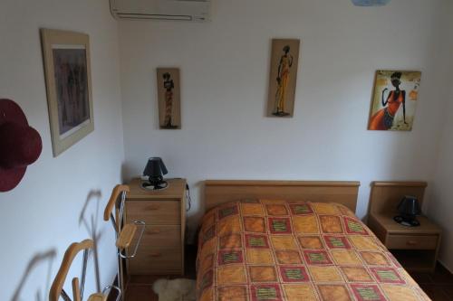 a bedroom with a bed and some pictures on the wall at Patrimonio chambre avec commodités chez l’habitant in Patrimonio