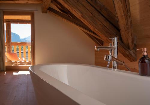 eine weiße Badewanne in einem Zimmer mit Fenster in der Unterkunft Casa Caminada in Fürstenaubruck