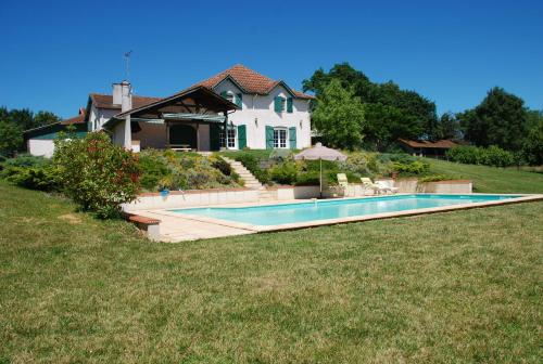 une maison avec une piscine devant une maison dans l'établissement Domaine Sainte Barthe, entre Marciac et Nogaro, à Aignan