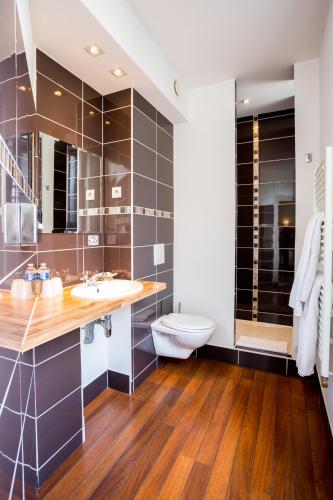 une salle de bain avec un lavabo et des toilettes dans l'établissement Best Western Hôtel Des Voyageurs, à Fougères