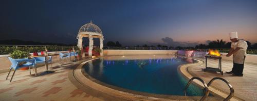 a chef standing next to a swimming pool at a hotel at Windsor Rajadhani Hotel in Trivandrum