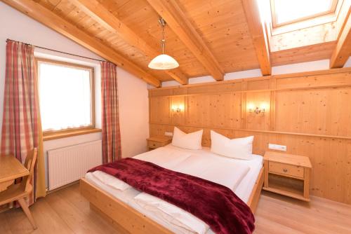 a bedroom with a bed in a wooden room at Das GÄSTEHAUS SCHNEIDER am Dorfplatz in Alpbach