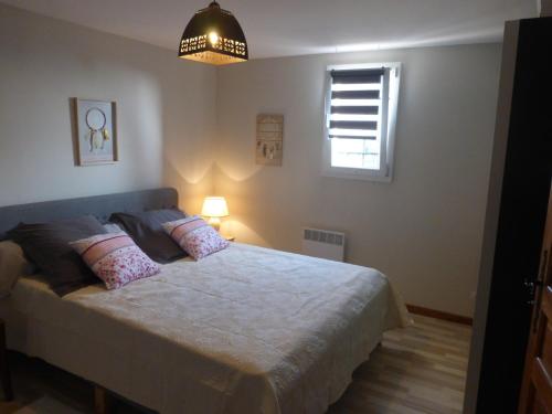 une chambre avec un lit avec des oreillers et une fenêtre dans l'établissement lou farniente, à Flayosc