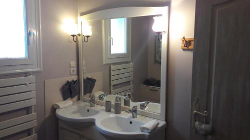 La salle de bains est pourvue de 2 lavabos et d'un grand miroir. dans l'établissement chambre d'hôte - La ruche des Bleuets, à Mulsanne
