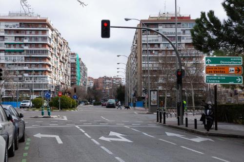 an empty city street with a traffic light and buildings at Apartamentos Duque Ventas in Madrid