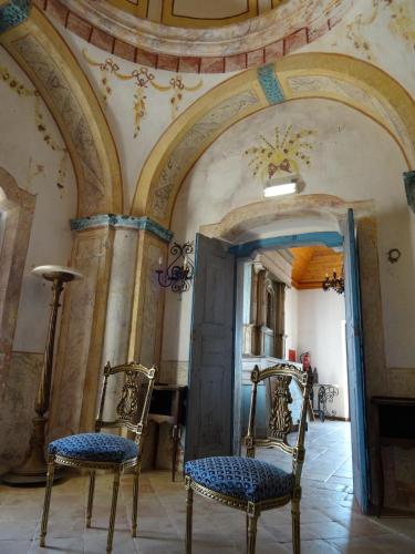 a room with two chairs and a mirror at Hotel de Charme Capela das Artes in Armação de Pêra