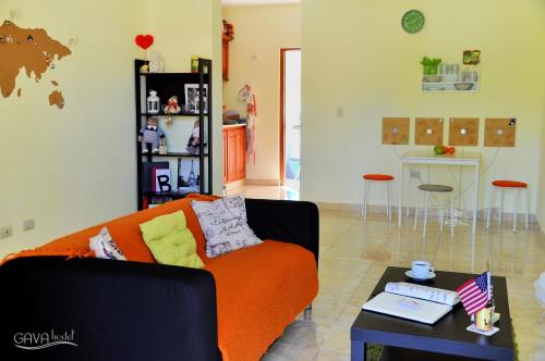 a living room with an orange couch and a table at GAVA hostel in Punta Cana