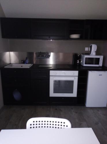 a kitchen with a white stove and a microwave at gite odeau in Sargé-sur-Braye