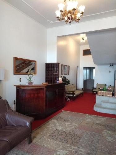 a living room with a couch and a chandelier at Hotel San Carlos in Carlos Barbosa