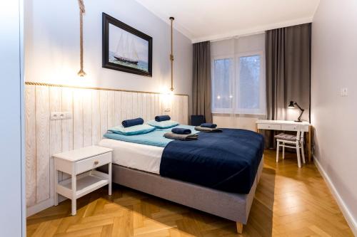 ein Schlafzimmer mit einem großen Bett und einem Schreibtisch in der Unterkunft Saltwater Apartment in Sopot