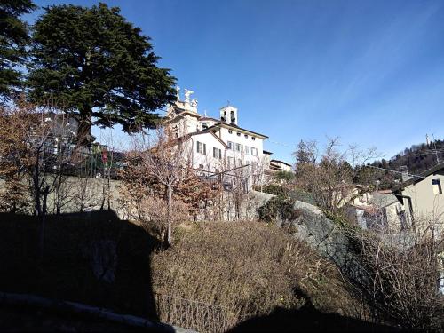 a large white building on a hill with trees at Via Funicolare in Brunate
