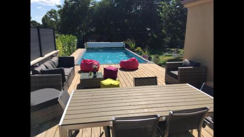 - une table et des chaises en bois à côté de la piscine dans l'établissement Chez Stéphane et Emilie, à Grenade