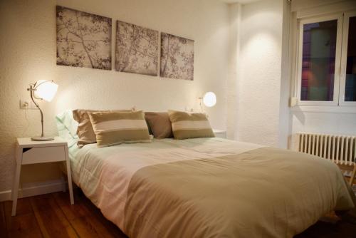 a bedroom with a large white bed with two lamps at Casa Andrea in Pamplona