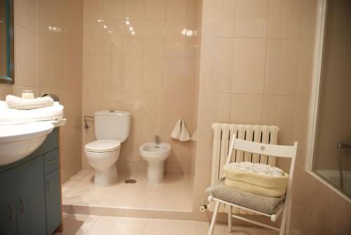 uma casa de banho branca com um WC, um lavatório e um WC. em Casa Andrea em Pamplona