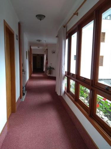 an empty hallway with windows in a building at Hotel San Carlos in Carlos Barbosa
