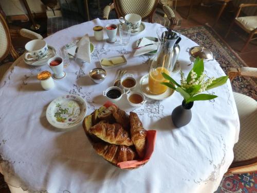 une table avec un tissu de table blanc et une assiette de pain dans l'établissement La Maison du Closier, à Blois