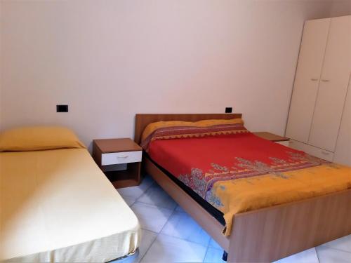 - une petite chambre avec 2 lits et une table de nuit dans l'établissement Locanda Cuore di Mare - 2, à Vasto