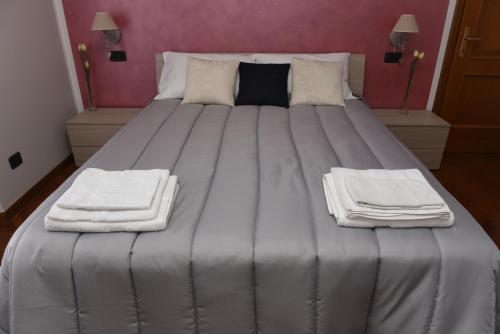 a large bed with towels on it in a room at Welcome Garden in Romano di Lombardia