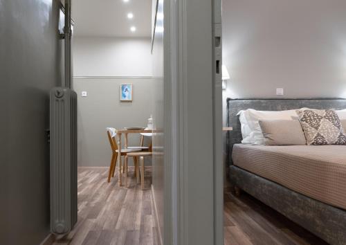 a bedroom with a bed and a table with a chair at Αbsolute Athens VIII in Athens