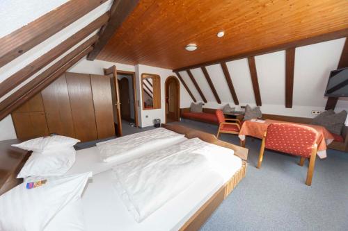 a bedroom with a large bed and a living room at Pension Panoramablick in Durbach