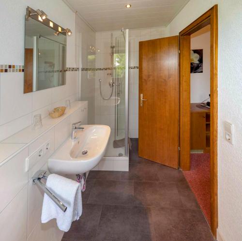 a white bathroom with a sink and a shower at Pension Panoramablick in Durbach