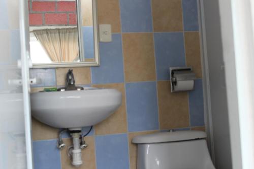 a bathroom with a sink and a toilet and a mirror at Hotel Villas del Rey in Chachalacas