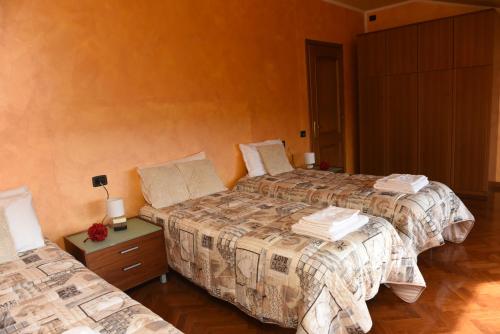 a bedroom with two beds and a night stand with two beds at Casa Dante in Romano di Lombardia