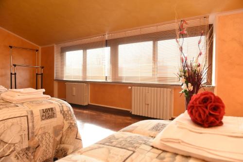 a bedroom with two beds and a large window at Casa Dante in Romano di Lombardia
