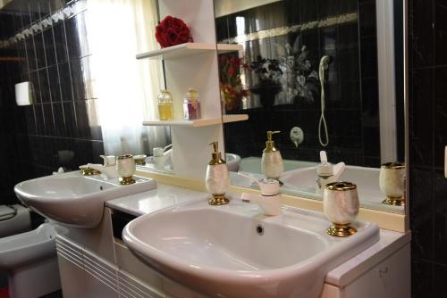 a bathroom with two sinks and a mirror at Casa Dante in Romano di Lombardia