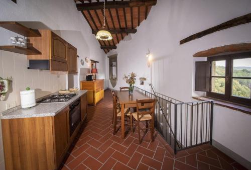 a kitchen with a table and a dining room at Casa Selvolini - VOLPAIA in Radda in Chianti