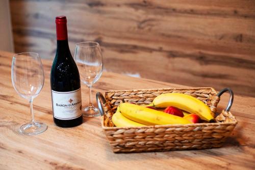 a basket of bananas and two wine glasses on a table at Apartmán Ježko in Tale